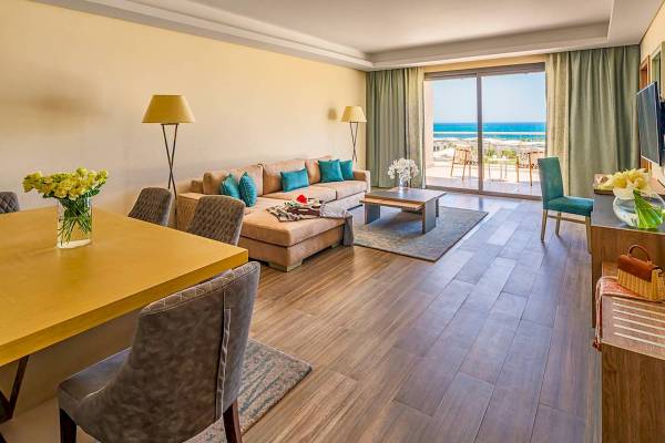 Hotellounge mit Blick auf das Meer und eine Terrasse mit Möbeln im Freien.