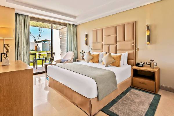 Schlafzimmer des Rixos Premium Magawish Suites & Villas mit großem Bett und Panoramafenster.