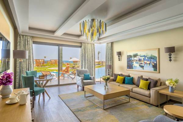 Luxuriöses Hotelzimmer mit großer Fensterfront, Blick auf den Pool, modernes Interieur.