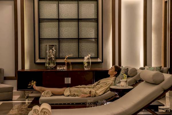 Frau im Wellnessbereich des Rixos Premium Magawish Suites & Villas Hotel, entspannt auf einer Liege