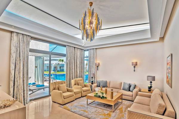 Wohnbereich eines Hotels mit Sofas, Tisch, Pool und Dekoration