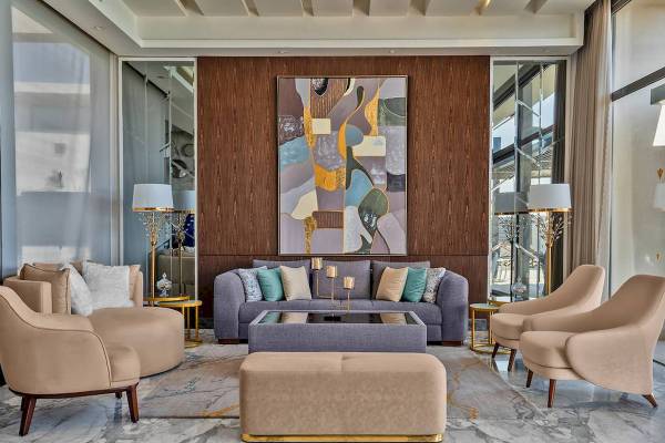 Hotel-Lounge-Bereich mit Sofa, Stühlen, Couchtisch und Gemälde an der Wand.