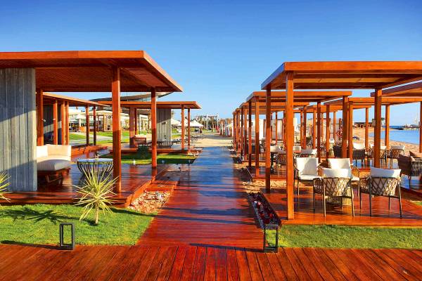 Holzterrassen im Hotel Rixos Premium Magawish Suites & Villas mit Blick auf den Strand