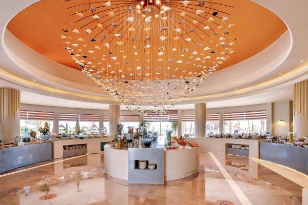 Lobby des Rixos Premium Magawish Suites & Villas mit großem Kronleuchter und Buffet