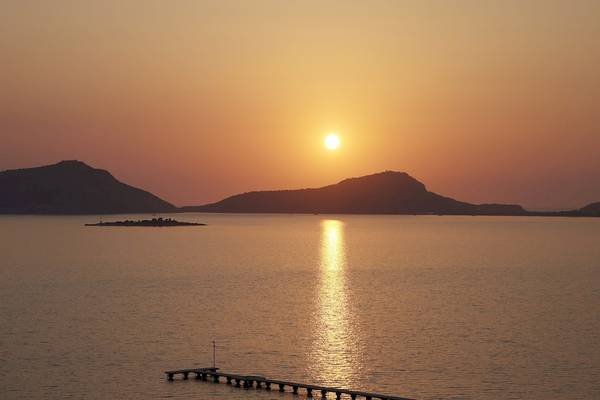 Sonnenuntergang über dem Meer mit Himmel und Bergen