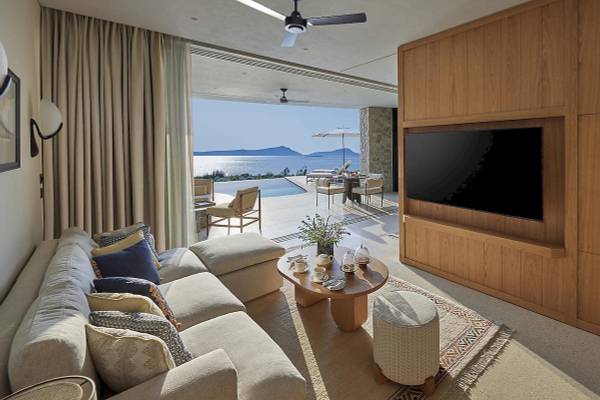 Wohnzimmer mit Meerblick im Mandarin Oriental, Costa Navarino, mit großer Couch, Beistelltisch und Fernseher.