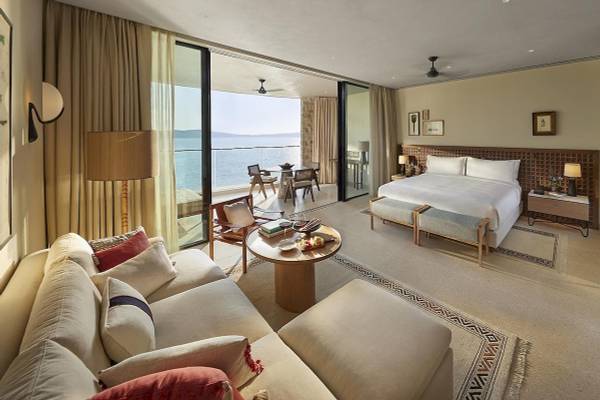 Suite im Mandarin Oriental, Costa Navarino mit Blick auf das Meer und ein modernes Interieurdesign.