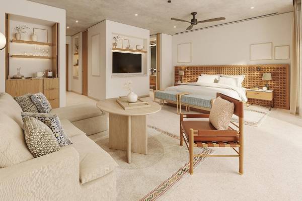 Innenansicht des Schlafzimmers im Mandarin Oriental, Costa Navarino, mit einem großen Bett, einem Esstisch und einem Sofa.