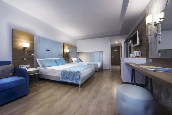 Innenansicht eines Doppelzimmers im Eftalia Ocean Hotel mit zwei Betten, einem Schreibtisch und einem Fernseher.