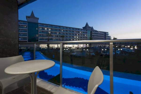 Hotelbalkon mit Aussicht auf das Schwimmbad bei Abendbeleuchtung, Eftalia Ocean.