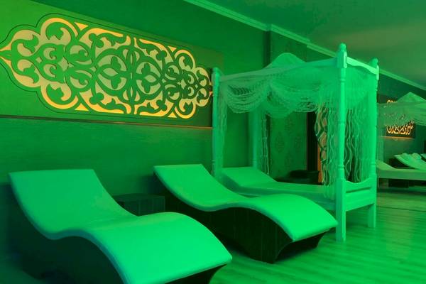 Gruener Loungebereich im Hotel Eftalia Ocean mit Loungeliegen und illuminierten Wanddekorationen