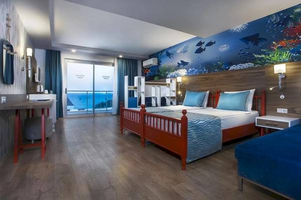 Hotelzimmer mit Meerblick und Wandgestaltung, die Unterwasserwelt darstellt.