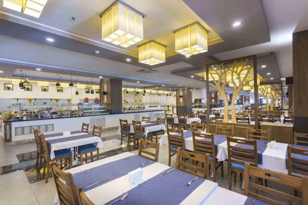 Innenansicht des Restaurants im Eftalia Ocean Hotel mit gedeckten Tischen und Buffet.