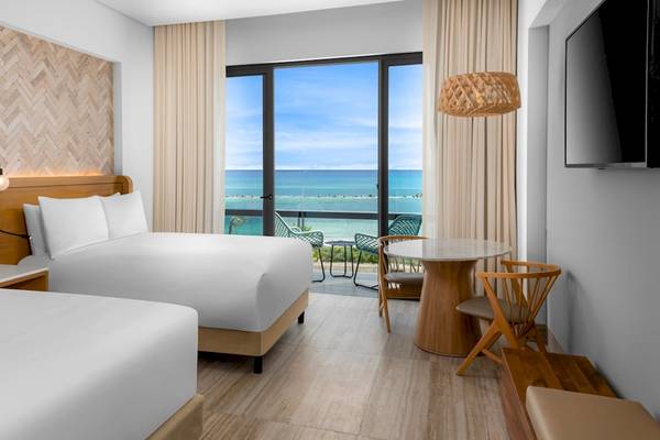 Hotelzimmer im Hilton Tulum Riviera Maya All-Inclusive Resort mit zwei Betten, Meerblick und moderner Einrichtung.