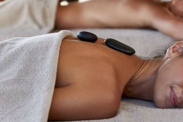 Massage im Hilton Tulum Riviera Maya All-Inclusive Resort mit zwei Frauen, eine schläft und eine genießt die Massage.