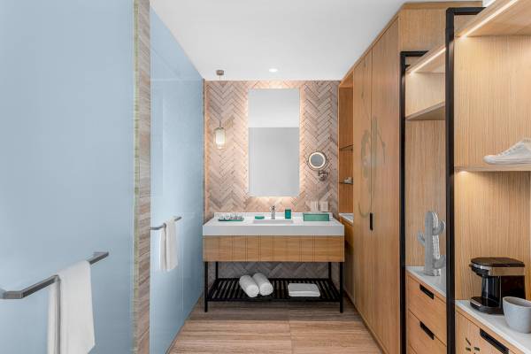 Badezimmer im Hilton Tulum Riviera Maya All-Inclusive Resort mit hellblauen Wänden und Holzakzenten.