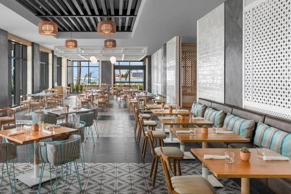Innenansicht des Restaurants im Hilton Tulum Riviera Maya All-Inclusive Resort mit modernen Möbeln und Meeresblick.