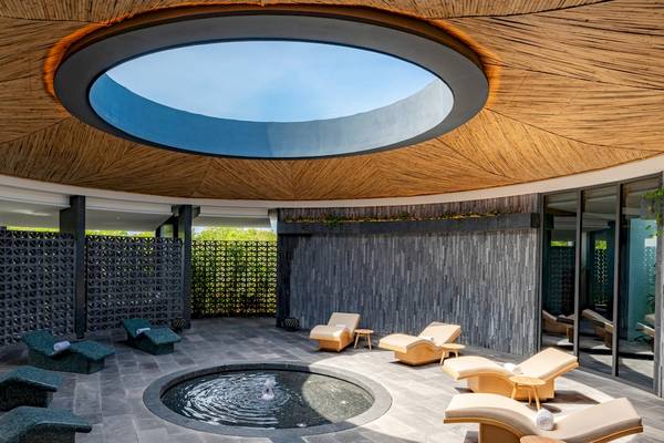 Spa-Bereich im Hilton Tulum Riviera Maya All-Inclusive Resort mit einer großen Fensteröffnung und Liegen.