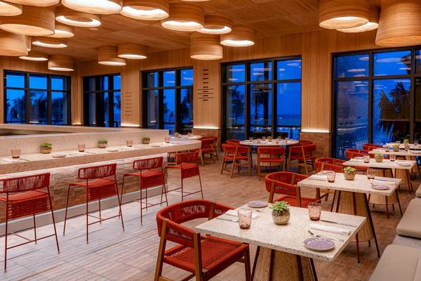 Innenbereich des Restaurants im Hilton Tulum Riviera Maya All-Inclusive Resort mit modernen Möbeln und großen Fenstern.