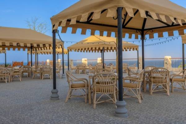 Terrasse mit Tischen und Stühlen im Siva Golden Bay Makadi Hotel.