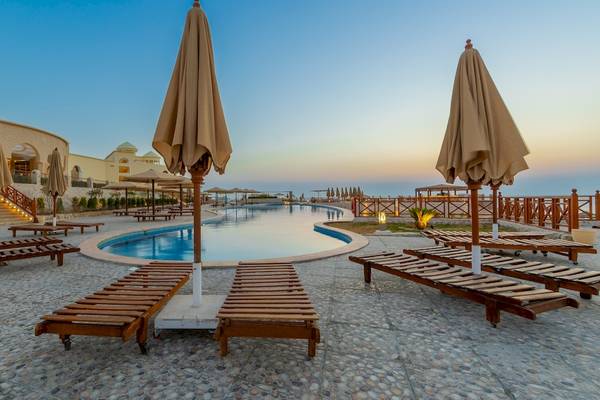 Außenbereich des Siva Golden Bay Makadi Hotels mit Pool und Liegestühlen.