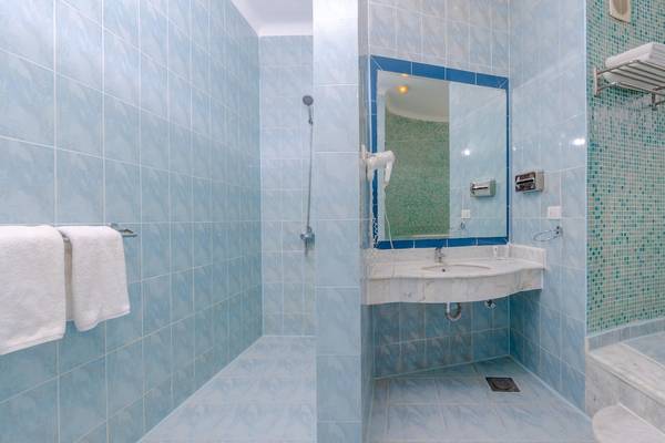 Ein Badezimmer im Siva Golden Bay Makadi Hotel mit blauen Fliesen und einer Dusche.