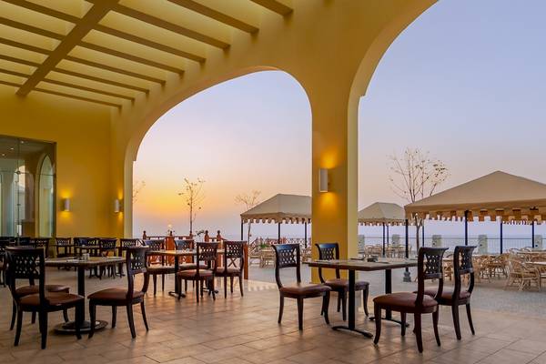 Terrasse des Siva Golden Bay Makadi Hotels mit Tischen und Stühlen.