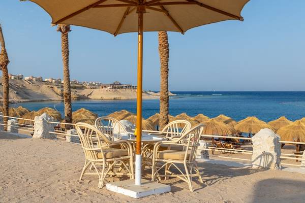 Siva Golden Bay Makadi Strand mit Tisch und Sonnenschirm.