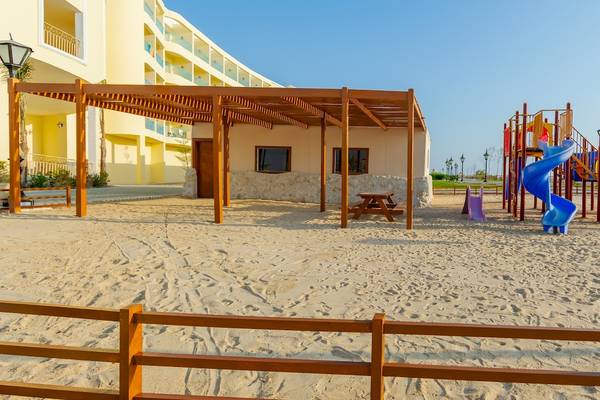 Spielplatz im Sand vor dem Siva Golden Bay Hotel mit Rutsche und Schaukeln.
