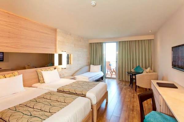 Doppelzimmer im Melas Resort mit zwei Betten, einem Sofa, Fernseher und Schreibtisch.