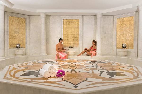 Innenansicht des Dampfbades im Melas Resort mit zwei Gästen und dekorativen Elementen.