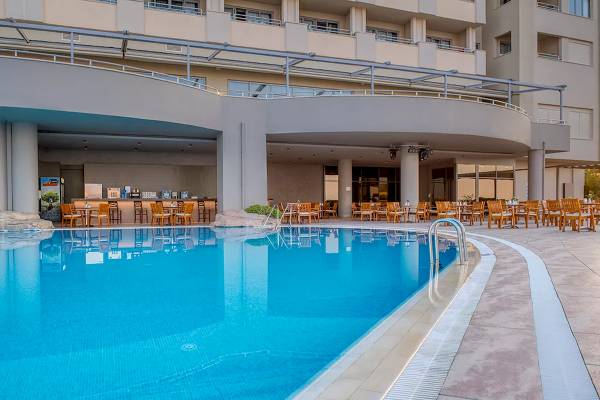 Außenbereich des Melas Resorts mit Swimmingpool und Sitzgelegenheiten rundherum.