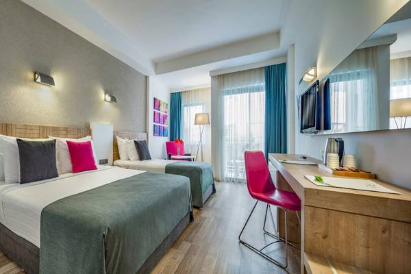 Innenansicht eines Doppelzimmers im Novum Garden Side Hotel mit zwei Betten und einem Schreibtisch.