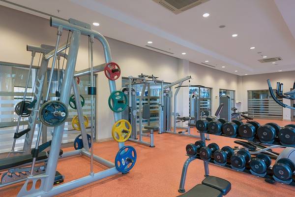 Fitnessbereich im Novum Garden Side Hotel mit verschiedenen Trainingsgeräten und Hanteln.