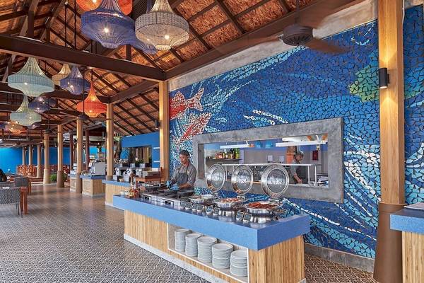 Innenbereich des Restaurants im Bandara Resort & Spa, Samui mit blauer Wand und Fischmosaik.