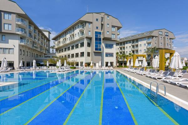 Außenpool des Novum Garden Side Hotels mit vielen Liegestühlen und Sonnenschirmen.