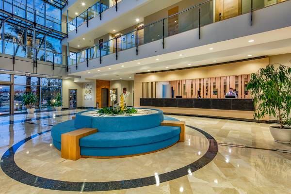 Empfangshalle des Novum Garden Side Hotels mit blauer Sitzbank und Rezeption.