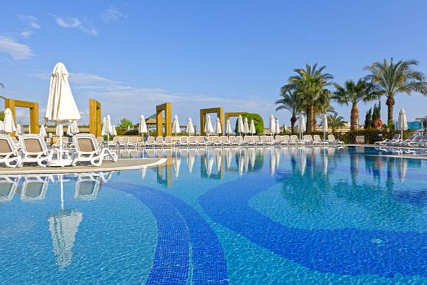 Außenpool des Novum Garden Side Hotel mit vielen Liegestühlen und Sonnenschirmen