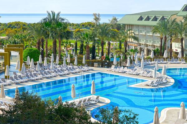 Außenpool des Novum Garden Side Hotel mit vielen Liegen und Sonnenschirmen.