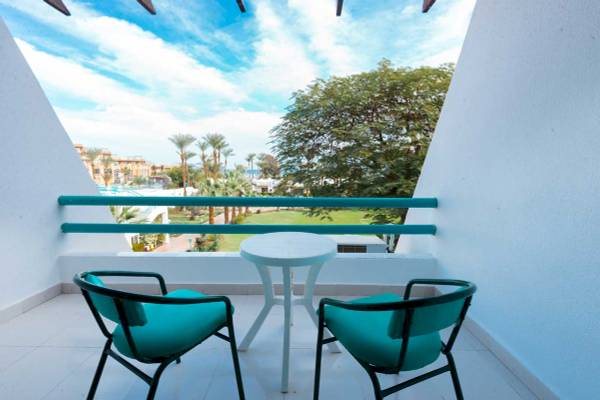 Balkon mit zwei blauen Stühlen und einem Tisch im Shams Safaga Resort