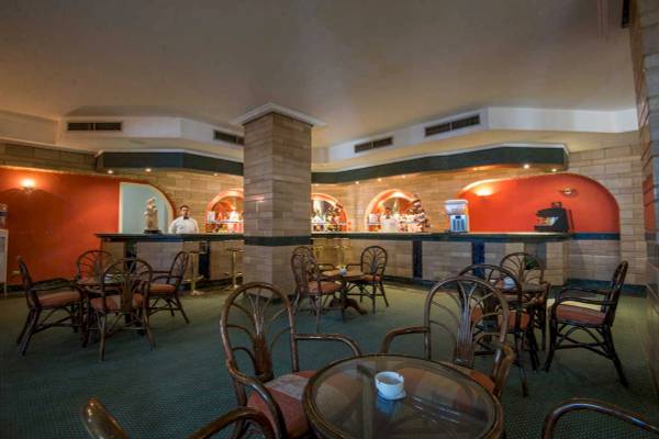 Hotelbar im Shams Safaga Resort mit Barkeepern und runden Tischen.