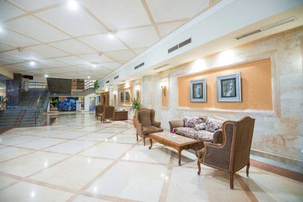 Lobby des Shams Safaga Resorts mit gefliestem Boden, Sofas, Tischen und Gemälden.
