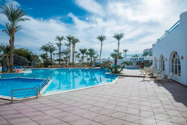 Außenbereich des Schwimmbads am Shams Safaga Resort mit Sonnenliegen und Palmen