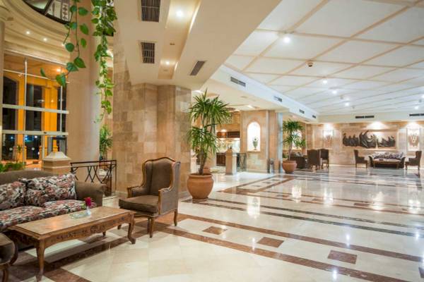 Lobby des Shams Safaga Resorts mit gemustertem Boden, Sofas, Tischen und Pflanzen.