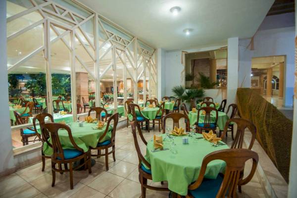Innenansicht des Restaurants im Shams Safaga Resort mit grün gedeckten Tischen und Stühlen.