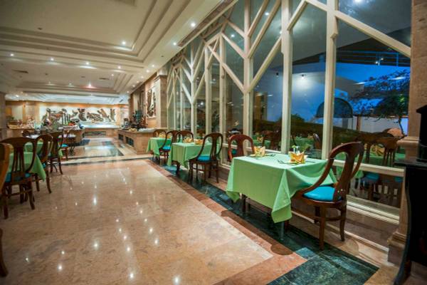 Innenansicht des Restaurants im Shams Safaga Resort mit grünen Tischen und Stühlen.