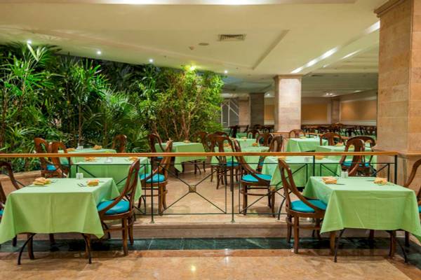 Innenansicht des Restaurants im Shams Safaga Resort mit grünen Tischen und Stühlen.