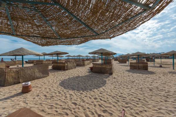 Strand mit vielen Strandhütten im Shams Safaga Resort bei einem blauen Himmel.