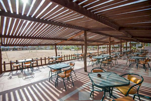 Terrasse des Shams Safaga Resorts mit Tischen und Stühlen im Freien.