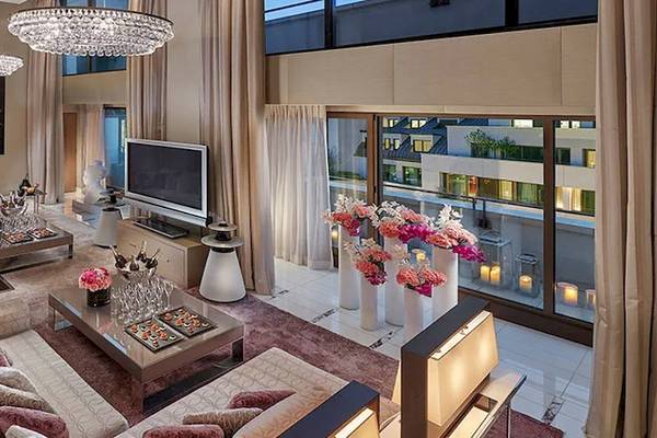 Das Wohnzimmer des Oberoi Beach Resort Al Zorah mit Sofas, Tischen, Fernseher und großen Fenstern.